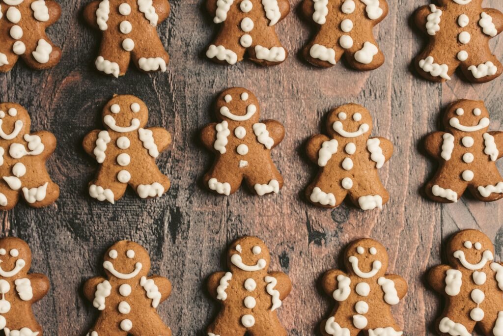 Rows of decorated gingerbread cookies laid out on a rustic wooden background, perfect for holiday themes.