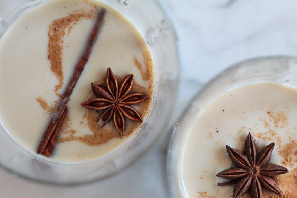 Top view of festive eggnog garnished with star anise and cinnamon, perfect for holiday celebrations.