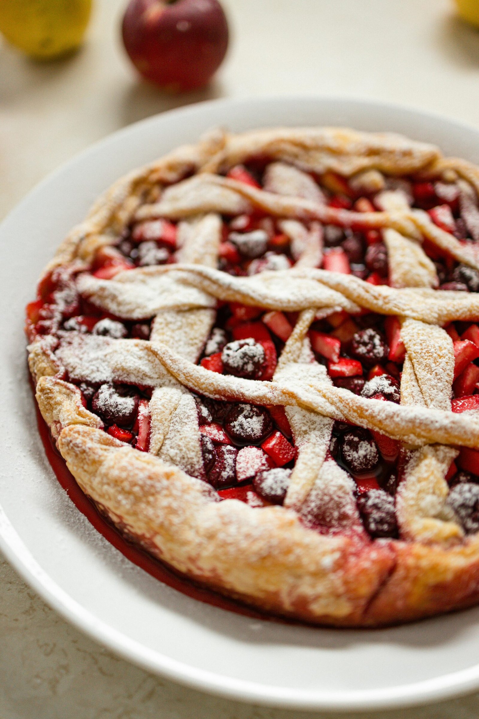 Delicious homemade berry pie with powdered sugar on top, freshly baked for a perfect treat.