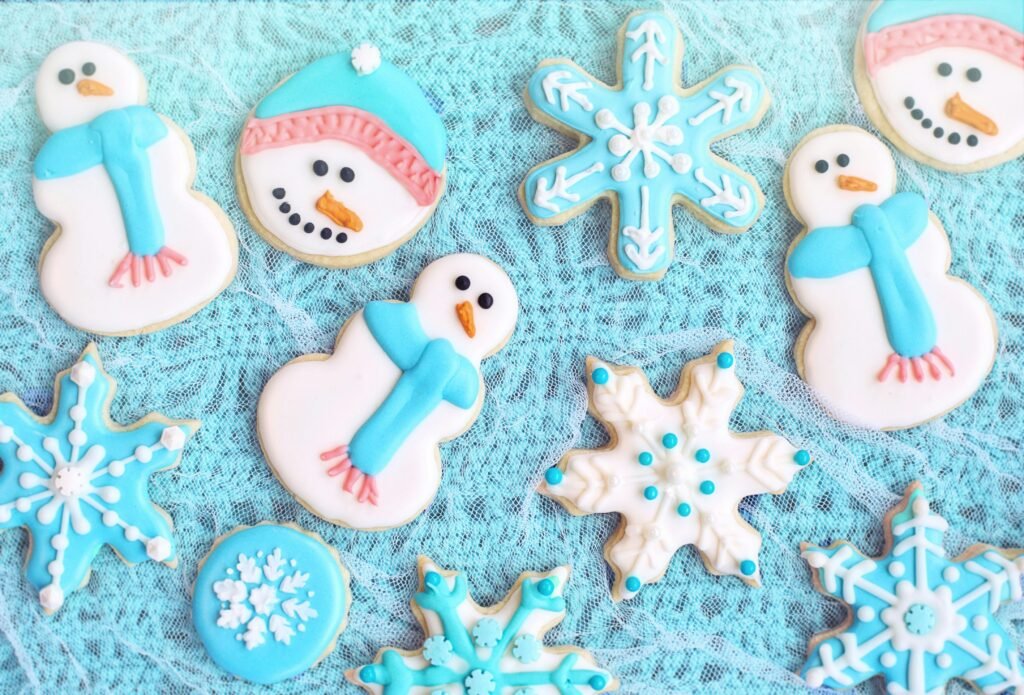 Top view of colorful snowman and snowflake cookies perfect for holiday festivities.